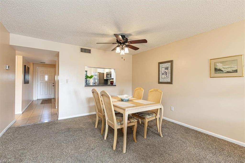 5535 Rattlesnake Hammock Road, Unit 302 Naples, FL 34113 - Photo 7 of 24 a dining room with furniture and a chandelier