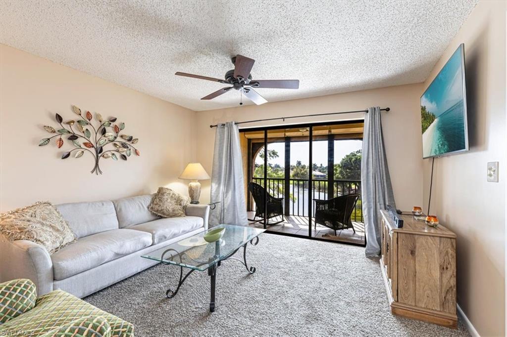5535 Rattlesnake Hammock Road, Unit 302 Naples, FL 34113 - Photo 8 of 24 a living room with furniture and a flat screen tv