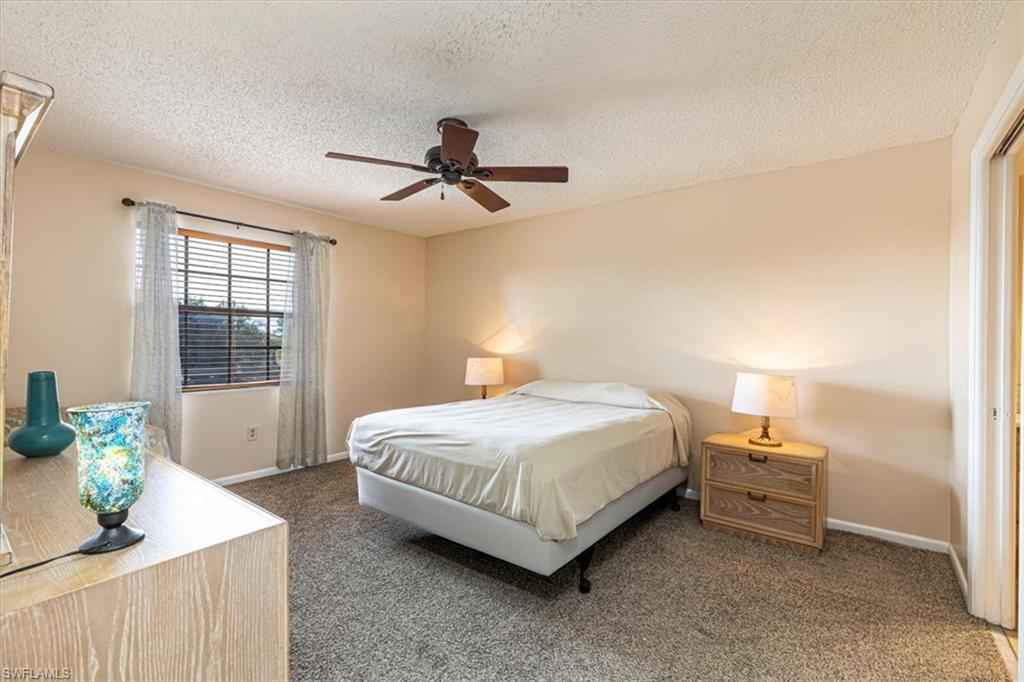 5535 Rattlesnake Hammock Road, Unit 302 Naples, FL 34113 - Photo 9 of 24 a bedroom with a bed and a chandelier