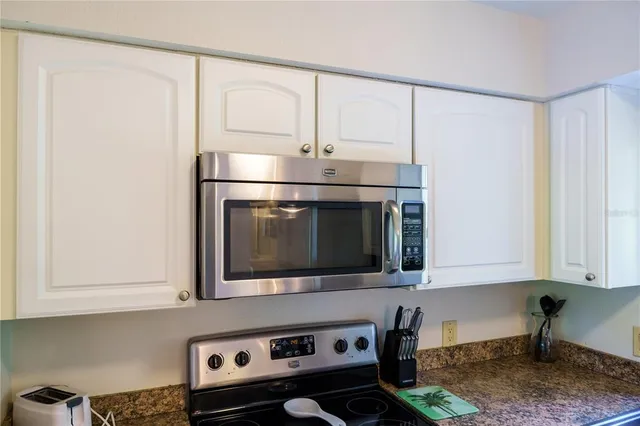 a kitchen with stainless steel appliances white cabinets and a stove top oven