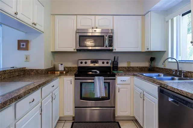 a kitchen with stainless steel appliances granite countertop a sink and a stove