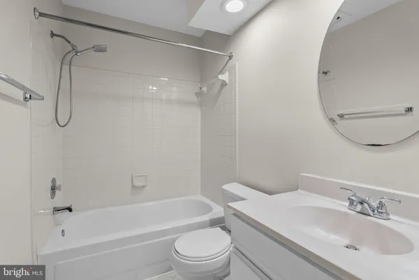 a bathroom with a bathtub shower sink vanity and toilet