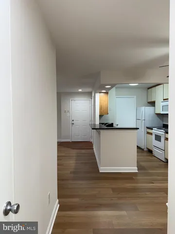 a view of kitchen and hall with wooden floor
