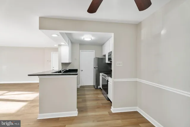 a kitchen with white cabinets and sink