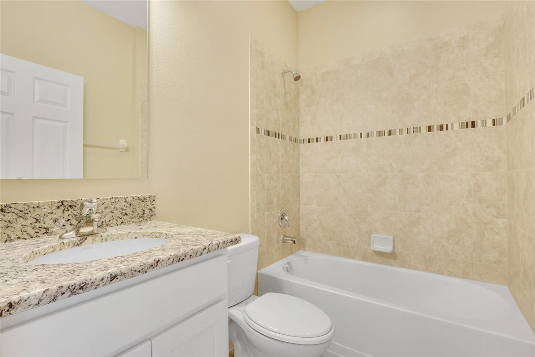 14 52nd Square Vero Beach, FL 32968 - Photo 15 of 25 a bathroom with a granite countertop sink a toilet and bathtub