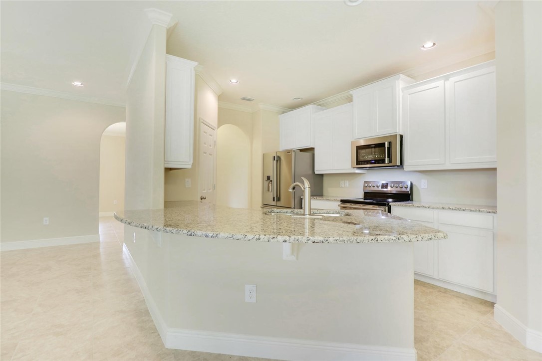 14 52nd Square Vero Beach, FL 32968 - Photo 7 of 25 a kitchen with stainless steel appliances granite countertop a sink a stove and a refrigerator
