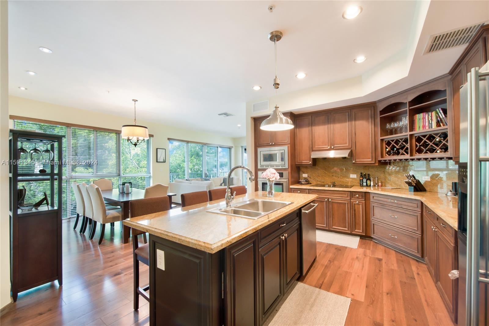 a large kitchen with kitchen island a sink a counter top space and stainless steel appliances