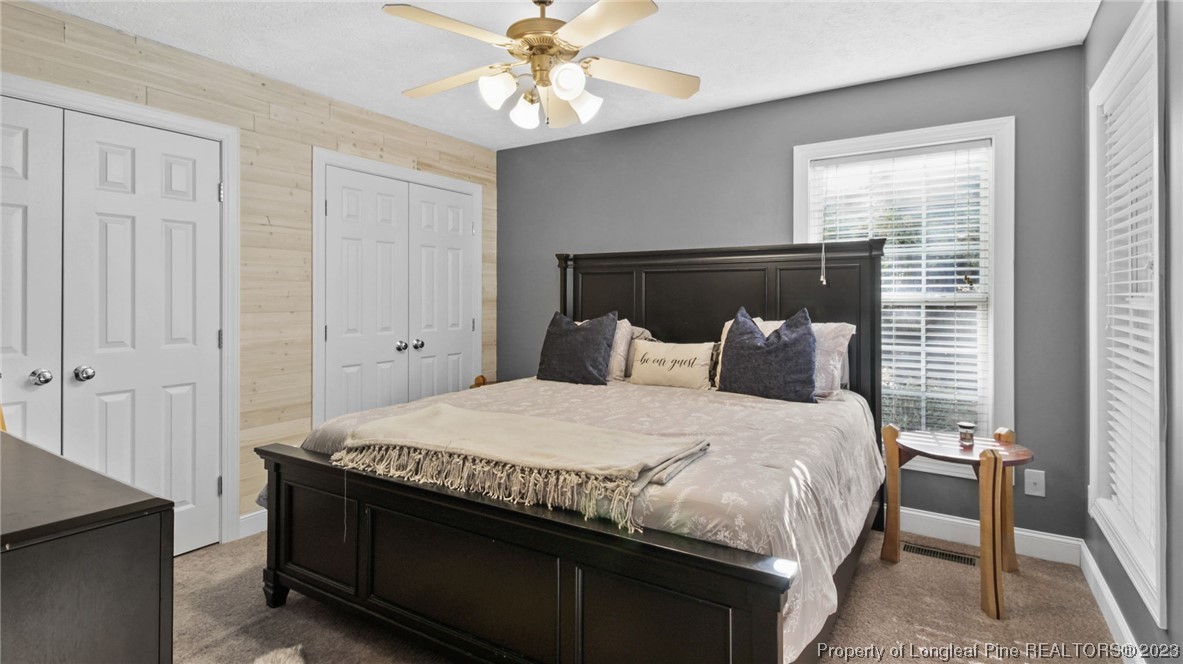 185 Russet Court Carthage, NC 28327 - Photo 15 of 32 a bedroom with a bed and a chandelier