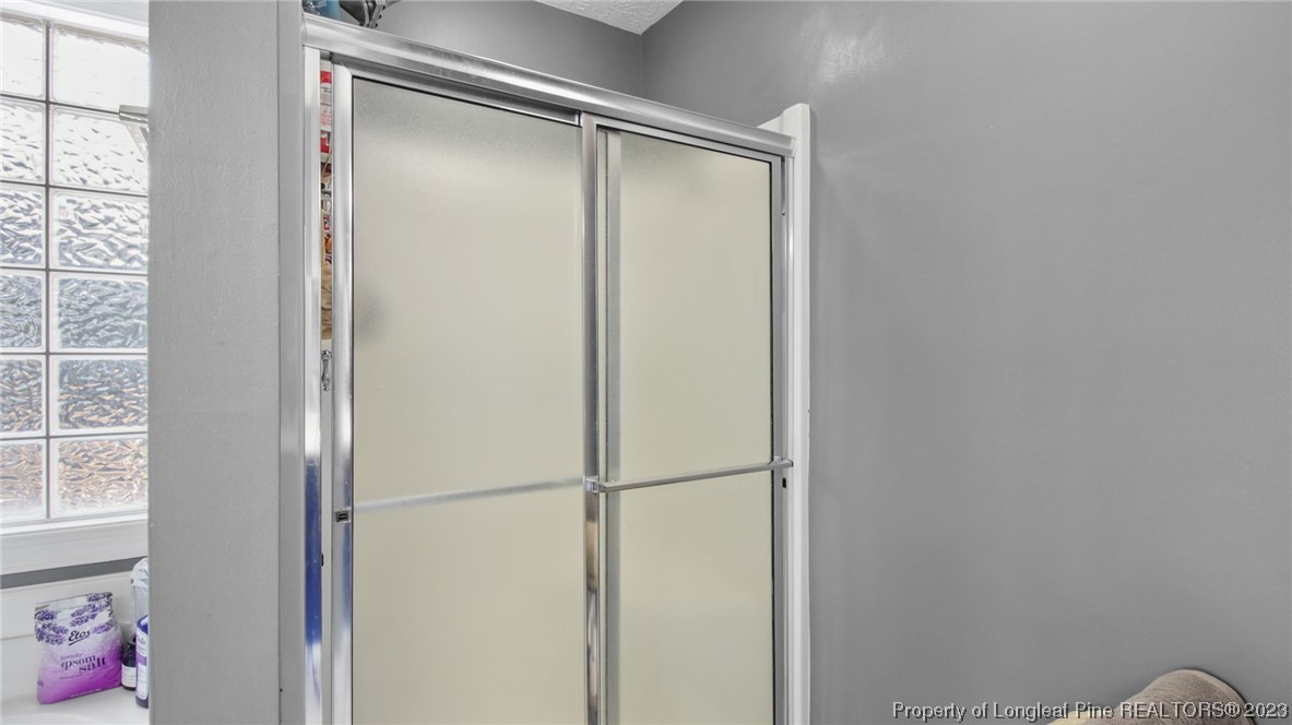 185 Russet Court Carthage, NC 28327 - Photo 26 of 32 a bathroom with a glass shower door