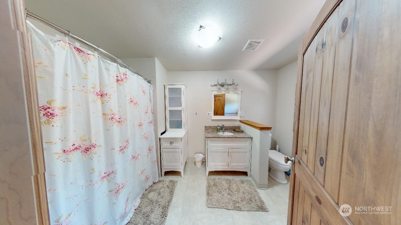 216 Tucannon Road Dayton, WA 99328 - Photo 14 of 39 a bathroom with a shower curtain and a sink