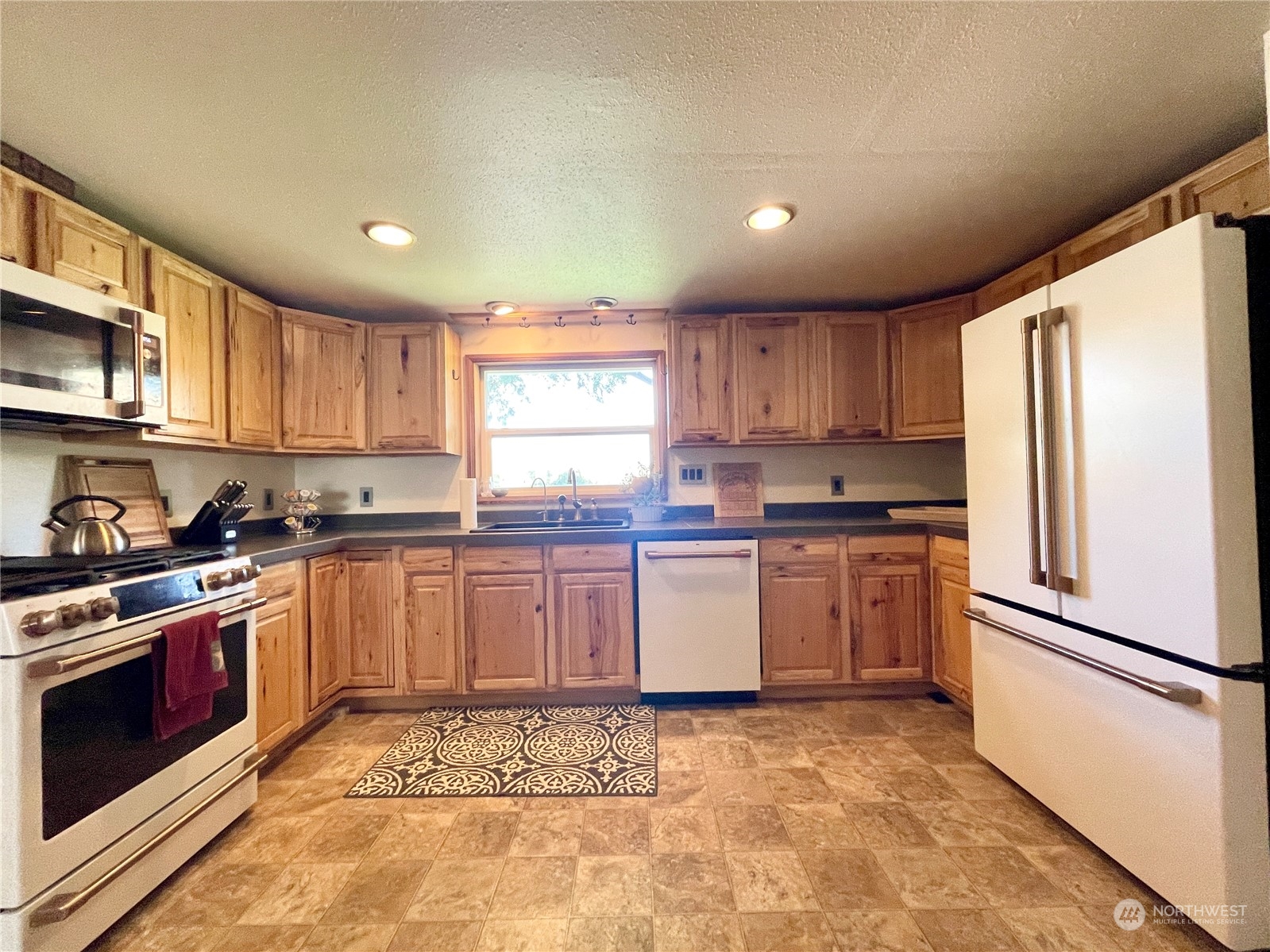 216 Tucannon Road Dayton, WA 99328 - Photo 4 of 39 a kitchen with granite countertop a refrigerator sink and cabinets