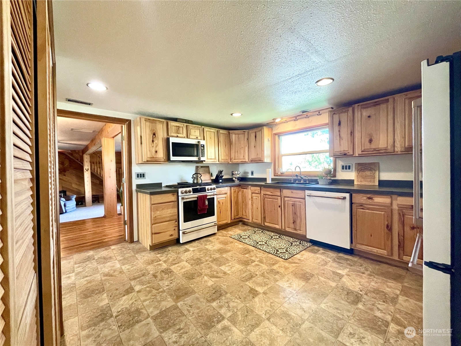 216 Tucannon Road Dayton, WA 99328 - Photo 5 of 39 a kitchen with granite countertop a stove top oven a sink dishwasher and a refrigerator