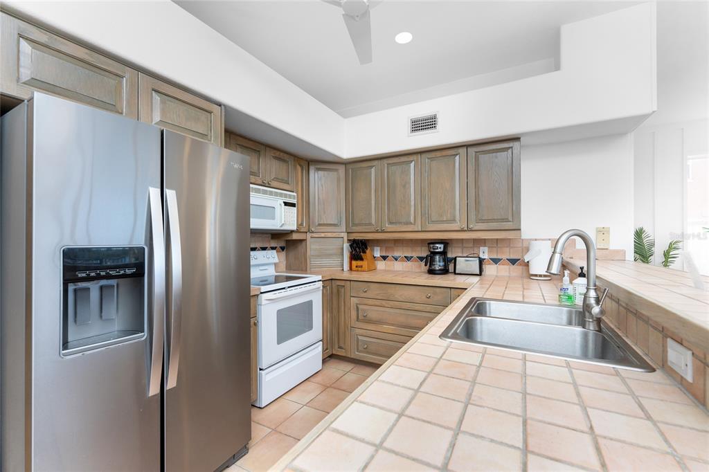 1400 Beach Road, Unit 1 Englewood, FL 34223 - Photo 23 of 68 a kitchen with stainless steel appliances granite countertop a refrigerator and a stove top oven