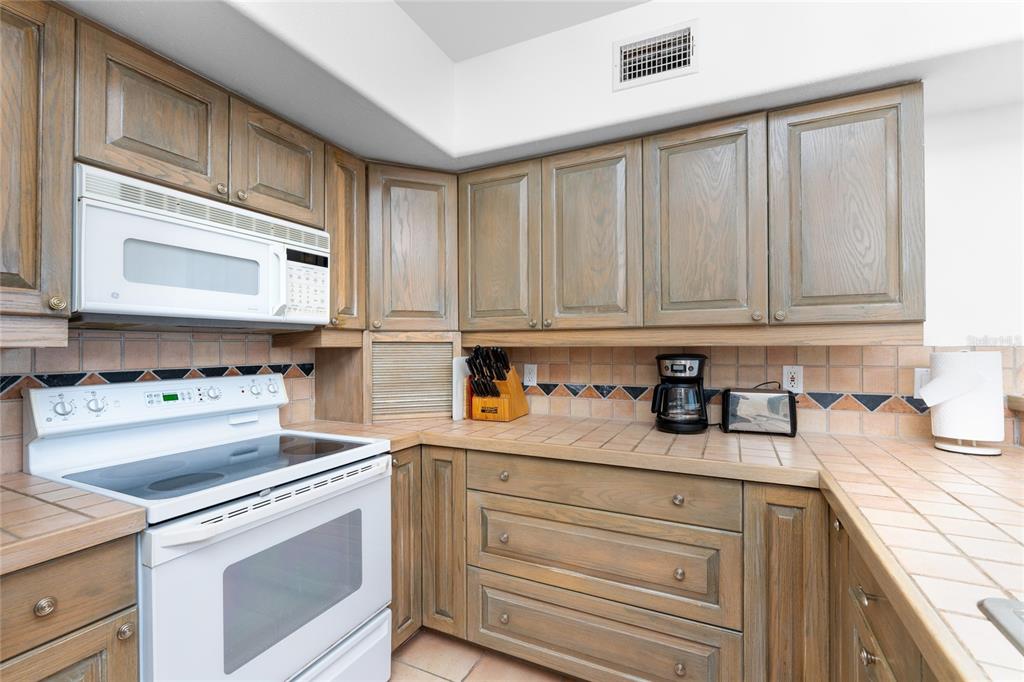 1400 Beach Road, Unit 1 Englewood, FL 34223 - Photo 24 of 68 a kitchen with granite countertop white cabinets and white appliances