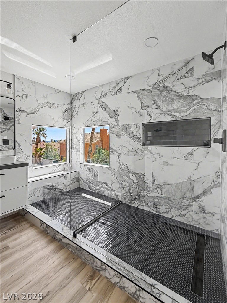 8977 Paige Rene Court Las Vegas, NV 89117 - Photo 3 of 31 Modern shower design featuring sleek marble walls and unique hex-tiled flooring.