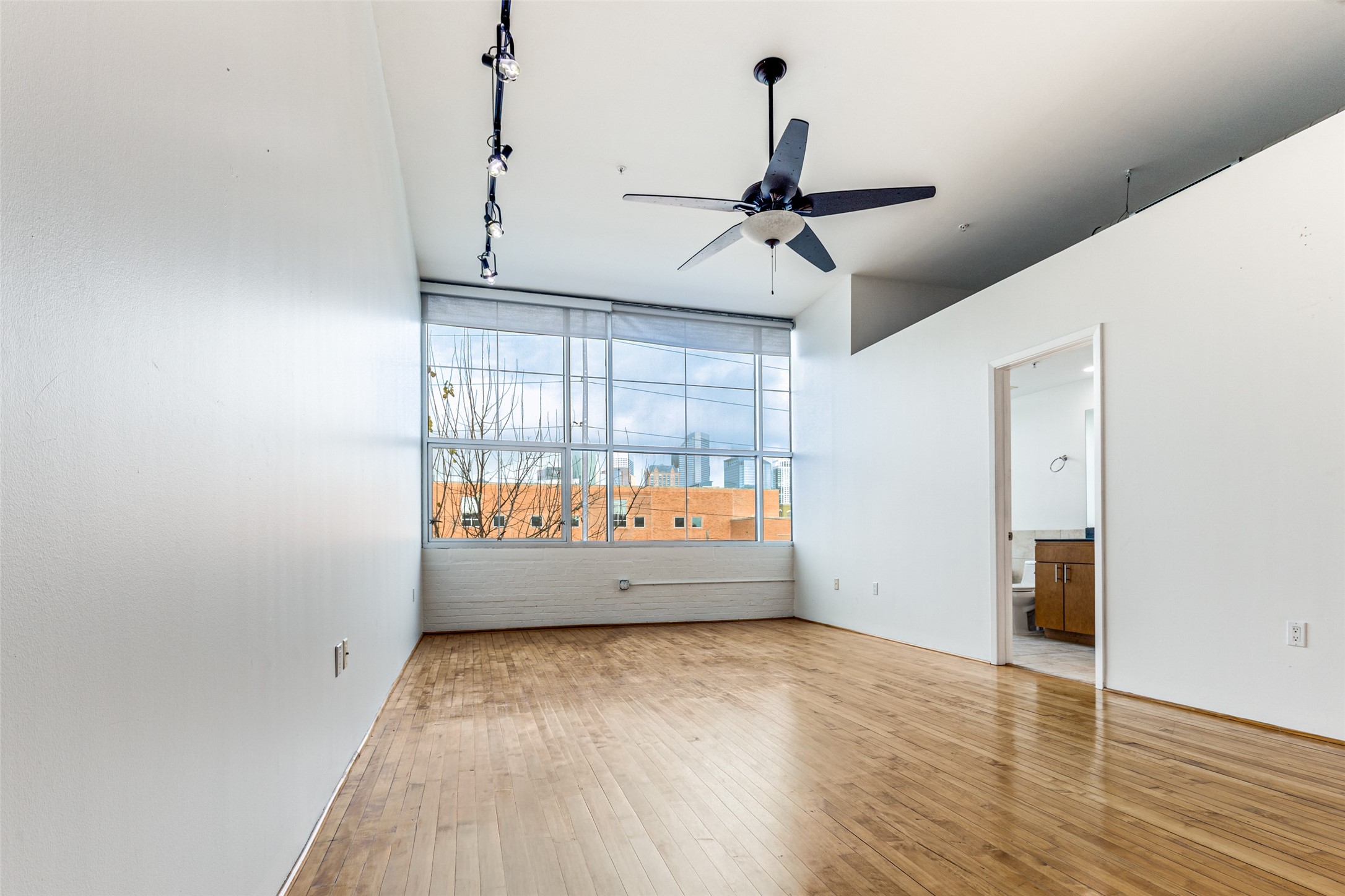 1312 Live Oak Street, Unit 223 Houston, TX 77003 - Photo 11 of 31 Primary bedroom featuring hardwood floors, recessed ceiling detail, and modern lighting.