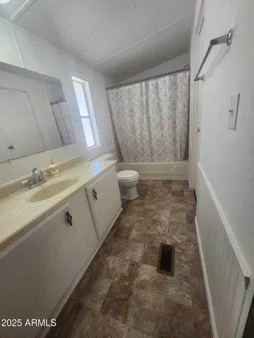 a bathroom with a granite countertop sink a toilet and shower