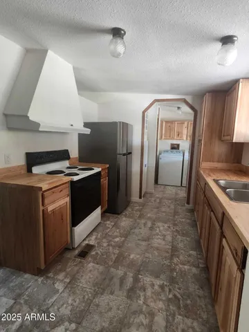 a kitchen with stainless steel appliances granite countertop a stove a refrigerator and a sink