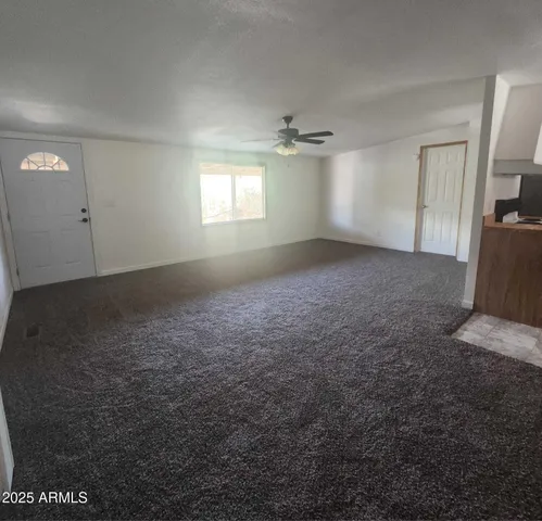 an empty room with windows and fireplace