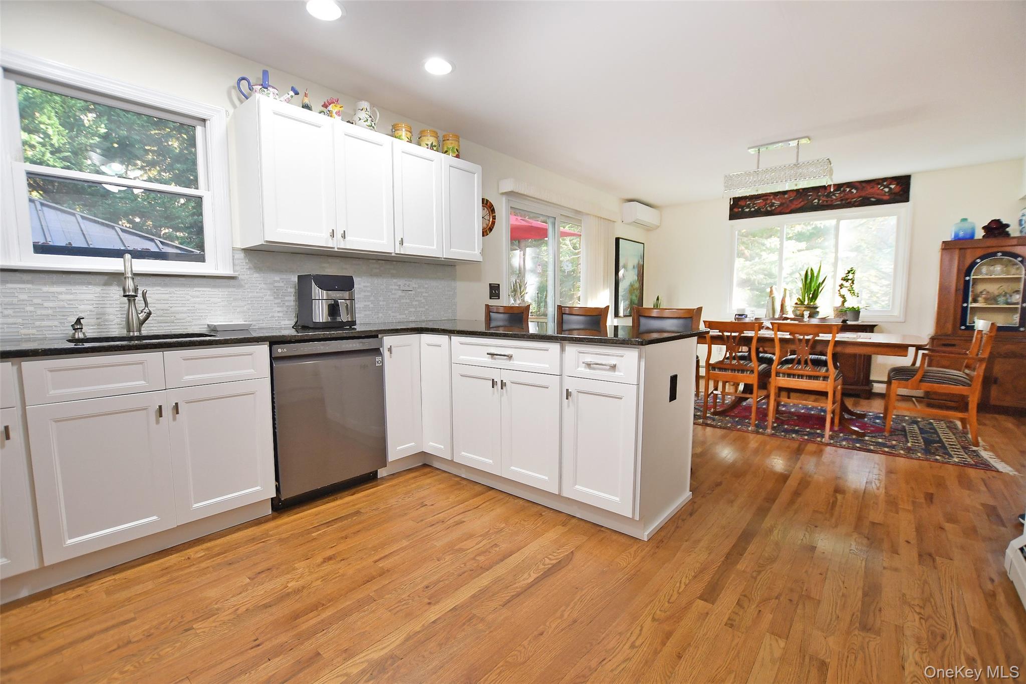64 Glen Road Baiting Hollow, NY 11933 - Photo 11 of 46 Kitchen featuring a peninsula, stainless steel dishwasher, tasteful backsplash, white cabinets, and plenty of natural light
