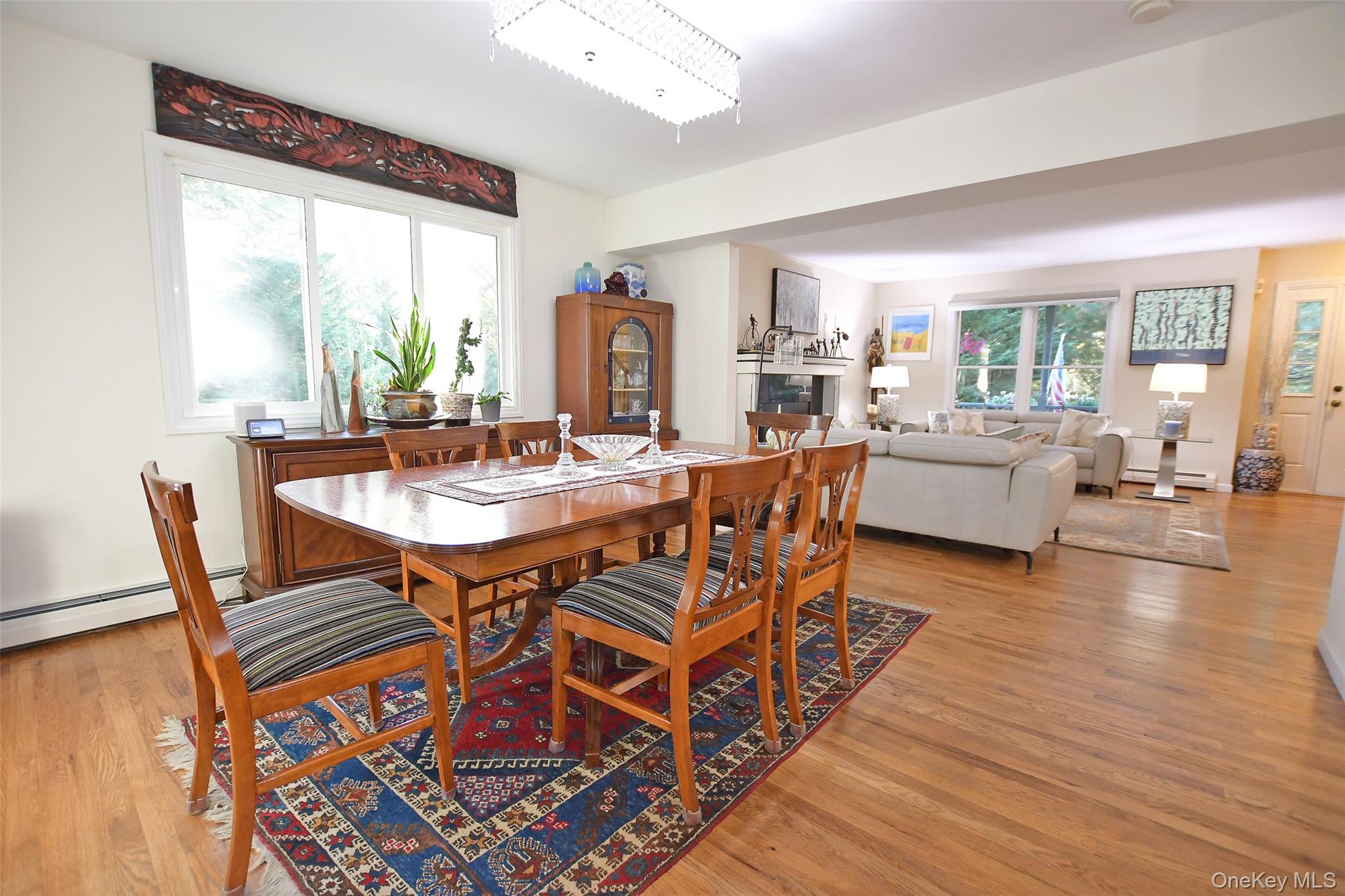 64 Glen Road Baiting Hollow, NY 11933 - Photo 12 of 46 Dining space with light wood-style floors, a glass covered fireplace, and baseboard heating