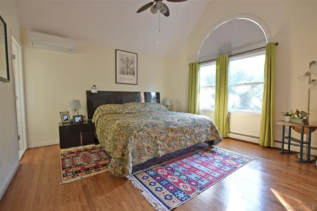 a living room with furniture and a dining table with wooden floor