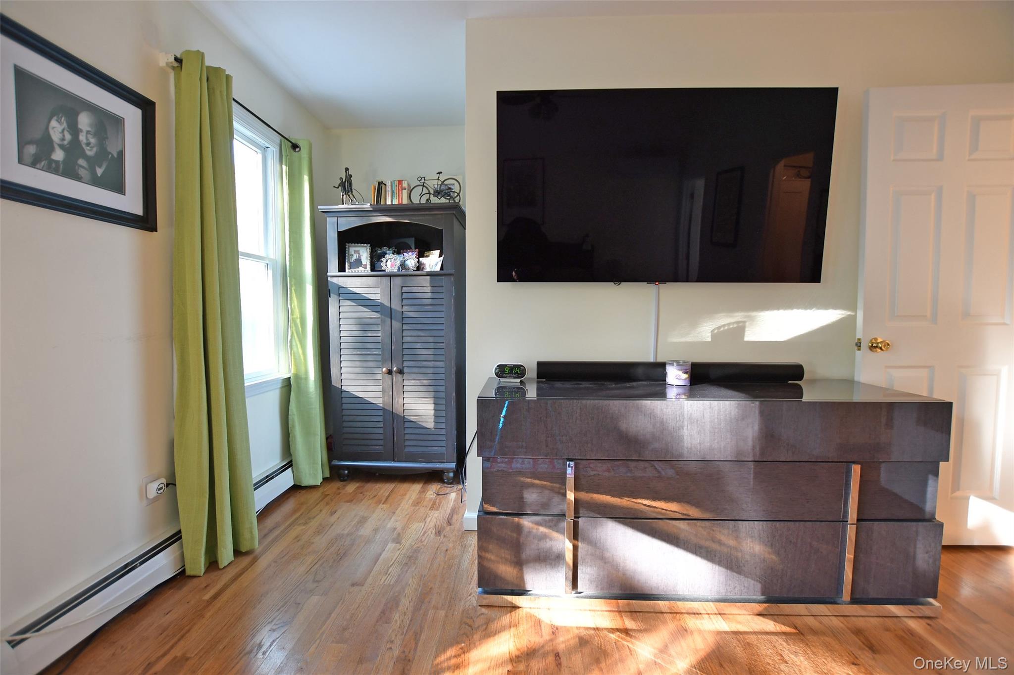 64 Glen Road Baiting Hollow, NY 11933 - Photo 18 of 46 Home office with light wood-style floors and a baseboard heating unit