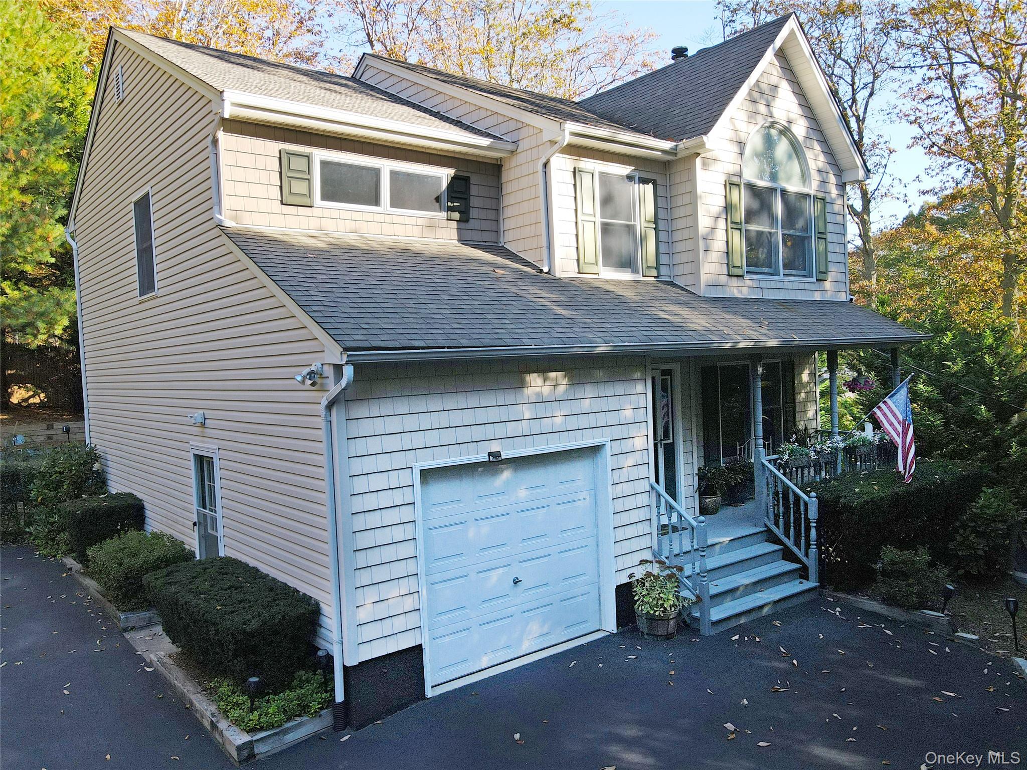 64 Glen Road Baiting Hollow, NY 11933 - Photo 2 of 46 View of front facade featuring an attached garage, roof with shingles, a porch, and asphalt driveway