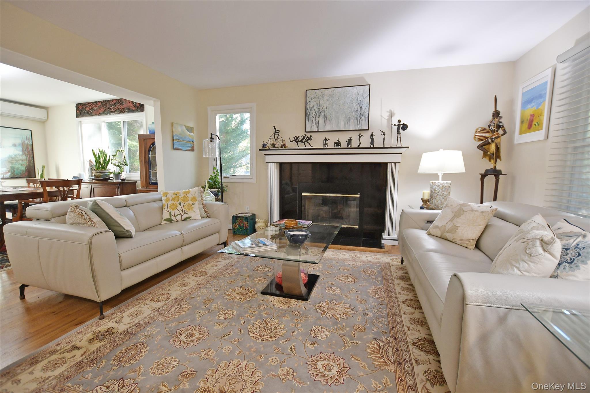 64 Glen Road Baiting Hollow, NY 11933 - Photo 4 of 46 Living area with a tile fireplace, wood finished floors, and a wall mounted air conditioner