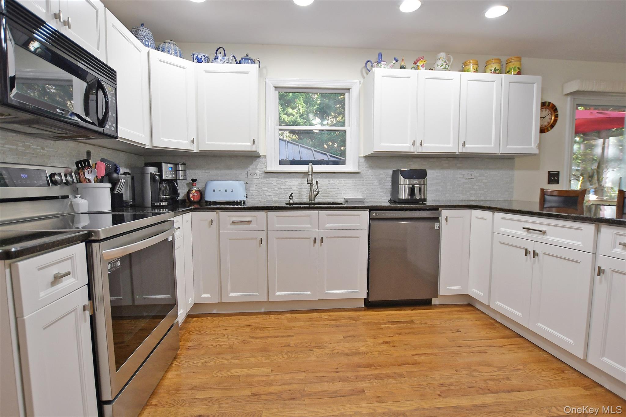 64 Glen Road Baiting Hollow, NY 11933 - Photo 8 of 46 Kitchen featuring stainless steel appliances, light wood-type flooring, white cabinetry, and recessed lighting