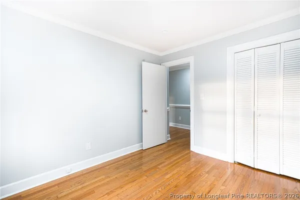 a view of empty room with wooden floor and entryway
