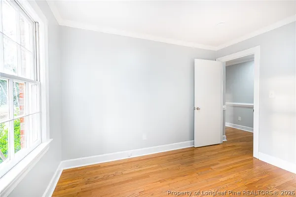 a view of empty room with wooden floor