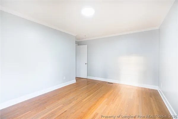 a view of an empty room with wooden floor