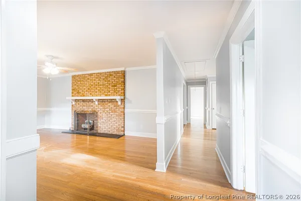a view of a hallway with wooden floor and living room