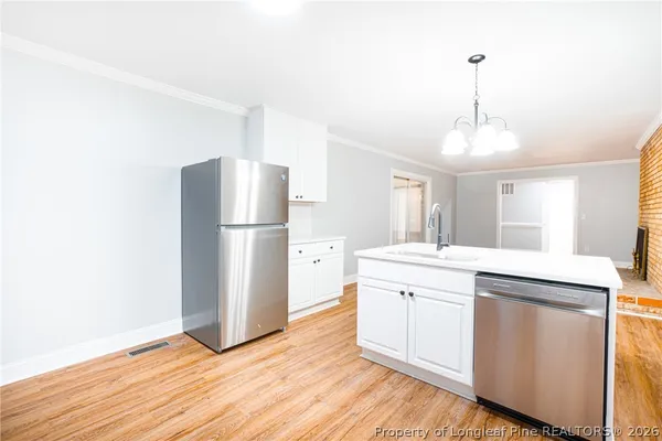 a kitchen with a refrigerator sink and cabinets