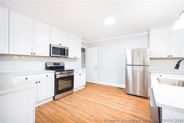 a kitchen with a refrigerator stove and white cabinets