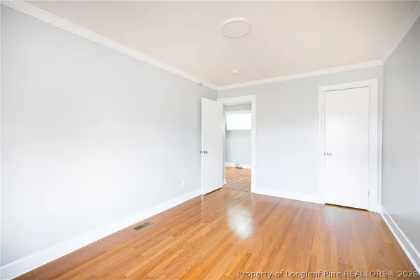 a view of an empty room with wooden floor