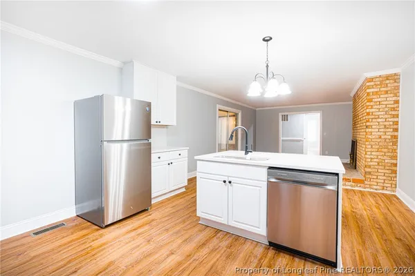 a kitchen with kitchen island white cabinets and wooden floor