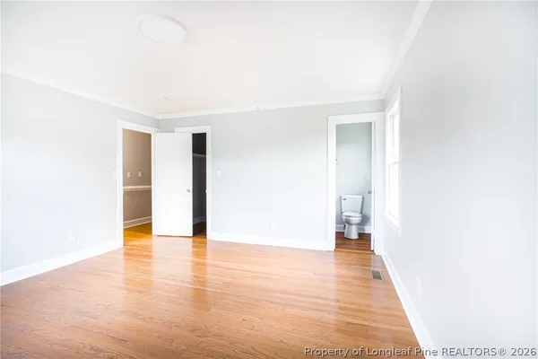 a view of an empty room with wooden floor