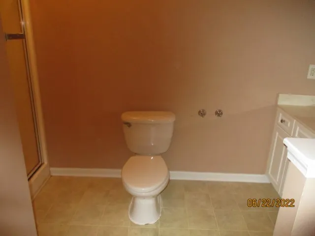 a white toilet sitting next to a shower