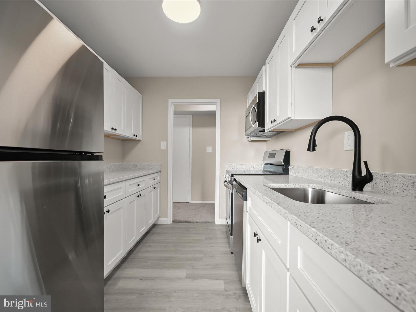 9701 Fields Road, Unit 1607 Gaithersburg, MD 20878 - Photo 5 of 26 a kitchen with white cabinets a sink and dishwasher