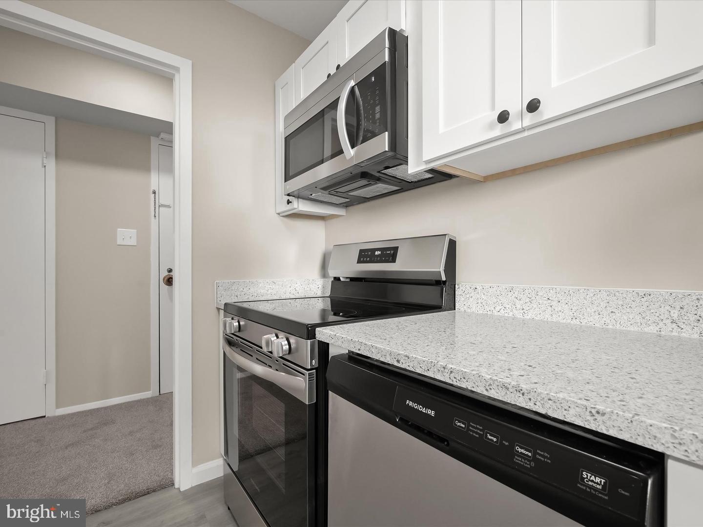9701 Fields Road, Unit 1607 Gaithersburg, MD 20878 - Photo 7 of 26 a kitchen with stainless steel appliances granite countertop a sink stove and microwave