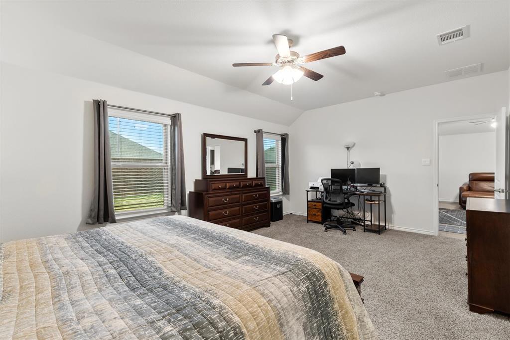 1302 Colonial Bluff Lane Princeton, TX 75407 - Photo 11 of 35 a spacious bedroom with a bed a dresser and a chandelier