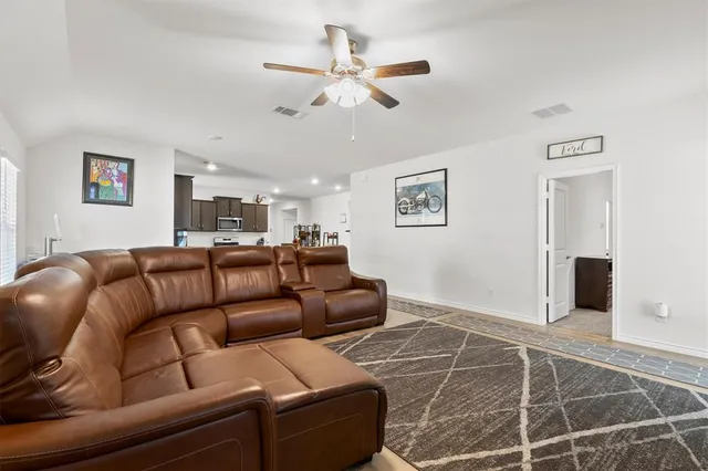 a living room with furniture and a ceiling fan