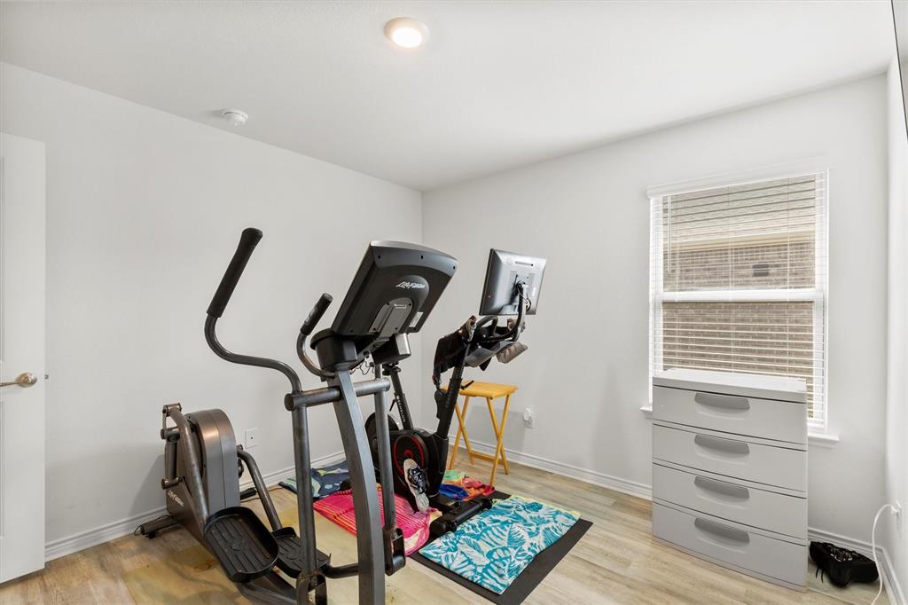 1302 Colonial Bluff Lane Princeton, TX 75407 - Photo 19 of 35 a room with gym equipment and windows