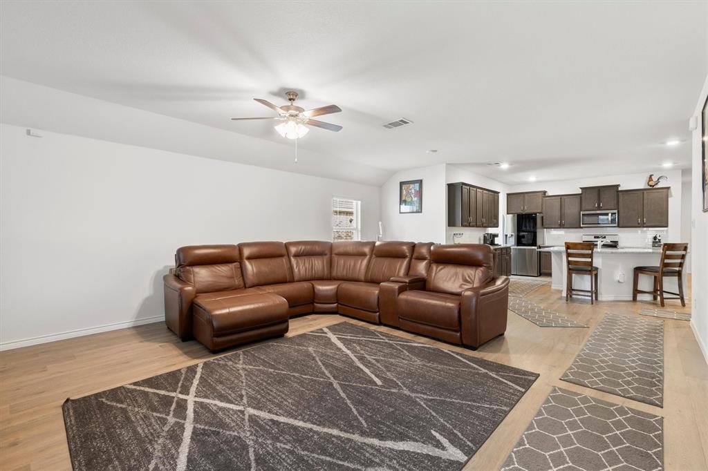 1302 Colonial Bluff Lane Princeton, TX 75407 - Photo 4 of 35 a living room with furniture a ceiling fan and a rug