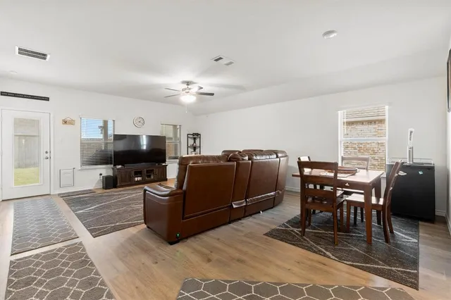 a living room with furniture a dining table and a piano table