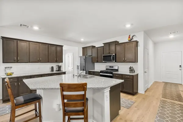 a kitchen with stainless steel appliances a sink stove top oven and cabinets
