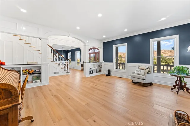 a view of a dining room and livingroom with furniture wooden floor a chandelier