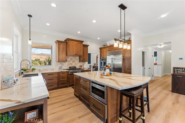 a kitchen with stainless steel appliances a table chairs stove and living room view